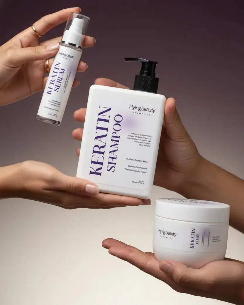 Three hands holding Keratin Serum, Shampoo, and Mask from Flynk Beauty against a gradient background.